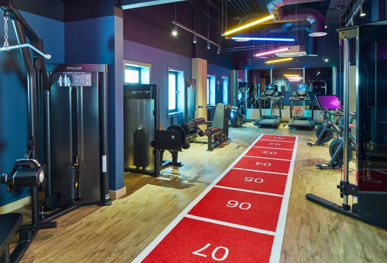 Gym with treadmills and red flooring at Leonardo Royal Hotel Edinburgh