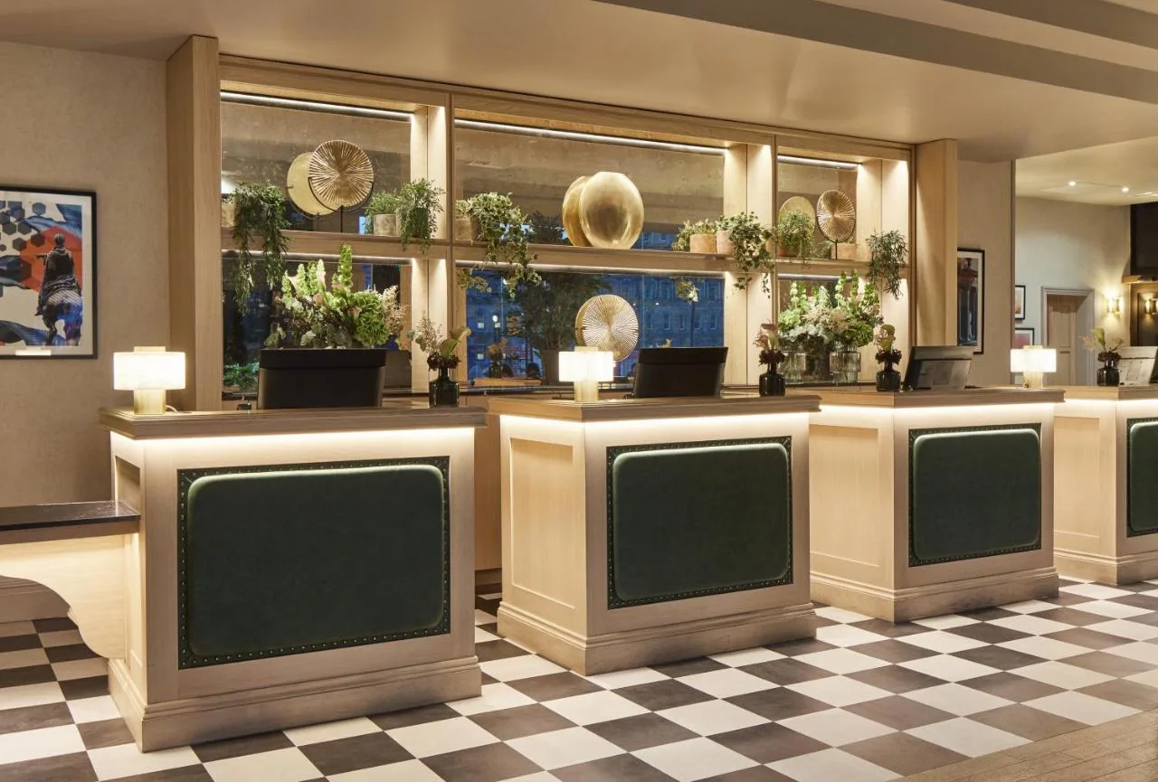 Hotel lobby with plants and a checkered floor near the Royal Mile